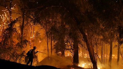 In this Oct. 31, 2019, file photo, a firefighter battles the Maria Fire in Somis, Calif. The CEO of the nation's largest utility is expected to face angry California lawmakers over the company's decision to turn off power for millions of people to prevent its outdated equipment from starting wildfires. Pacific Gas & Electric Corp. CEO Bill Johnson is scheduled to testify during a Legislative oversight hearing on Monday, Nov. 18, at the state Capitol. Lawmakers have repeatedly criticized the bankrupt company for leaving millions of people in the dark for days at a time during dry, windy weather events in October.