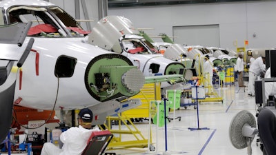 In this July 30, 2019, file photo people work in the production area at the Honda Aircraft Co. headquarters in Greensboro, N.C. where the HondaJet Elite aircraft is manufactured. On Friday, Nov. 1, the Institute for Supply Management, an association of purchasing managers, reports on activity by U.S. manufacturers in October.