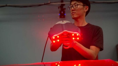 University of Cincinnati aerospace engineering student Yufeng Sun holds a laser scanner used to measure and render objects in three dimensions.