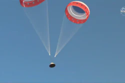 In this image made from a video provided by NASA parachutes guide the Starliner capsule to the ground after a test of Boeing's crew capsule's launch abort system in White Sands Missile Range in N.M., on Monday, Nov. 4, 2019. The capsule carried no astronauts Monday morning, just a test dummy.