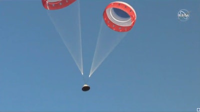 In this image made from a video provided by NASA parachutes guide the Starliner capsule to the ground after a test of Boeing's crew capsule's launch abort system in White Sands Missile Range in N.M., on Monday, Nov. 4, 2019. The capsule carried no astronauts Monday morning, just a test dummy.