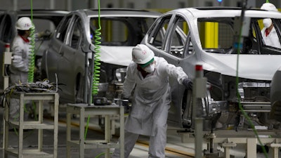 In this Feb. 21, 2014, file photo, employees at work in the new multibillion-dollar Honda car plant in Celaya, in the central Mexican state of Guanajuato.