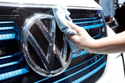 A worker shines the grill of a new Volkswagen electric car during a press conference at the Paris Motor Show, Sept. 29, 2016.