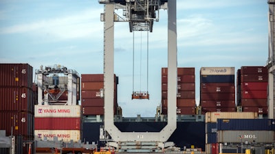 In this July, 5, 2018, file photo, a ship to shore crane prepares to load a 40-foot shipping container onto a container ship in Savannah, Ga.