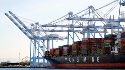 In this Nov. 4, 2019, file photo, cargo cranes take containers off of a Yang Ming Marine Transport Corp. boat at the Port of Tacoma.