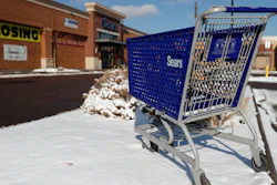 In this Jan. 1, 2019, file photo, an empty shopping cart sits outside a Sears store in the Streets of Southglenn mall in Littleton, Colo.