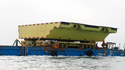 A yellow barrier, part of a plan to protect the city of Venice from flooding, floats on a barge, in Venice, Nov. 29, 2019.