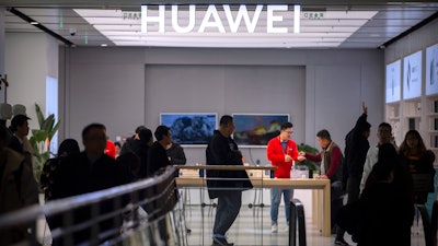 In this Nov. 20, 2019, photo, customers shop at a Huawei store in Beijing.