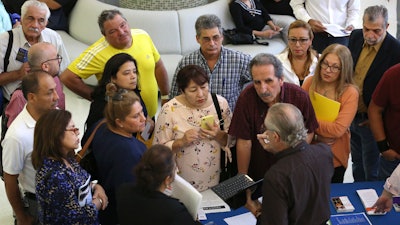 In this Sept. 18, 2019, file photo, people inquire about temporary positions available for the 2020 Census during a job fair in Miami.
