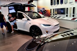 In this Aug. 8, 2018, file photo, customers check out the Tesla X at the Tesla showroom in Santa Monica, Calif.