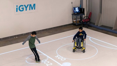 In this Nov. 17, 2019, photo, brothers Darren Kreps, left, and Bryan Kreps play a game modeled after soccer and air hockey in Ann Arbor, Mich.