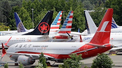 In this June 27, 2019, file photo, dozens of grounded 737 Max airplanes crowd a parking area adjacent to Boeing Field in Seattle.