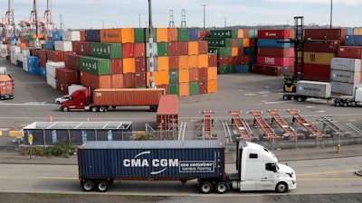 In this Oct. 2, 2019, file photo, trucks haul shipping containers at a terminal on Harbor Island in Seattle.
