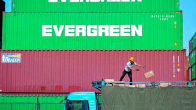 In this Oct. 14, 2019, file photo, a worker loads imported goods on a truck at a distribution company outside the container port in Qingdao, Shandong province.