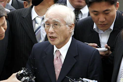 In this June 14, 2005, file photo, Kim Woo-choong, center, answers reporters' questions as he arrived at the Supreme Prosecutor's Office in Seoul.