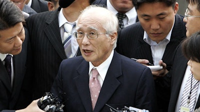 In this June 14, 2005, file photo, Kim Woo-choong, center, answers reporters' questions as he arrived at the Supreme Prosecutor's Office in Seoul.