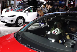 In this April 17, 2019, photo, attendees take a look at electric cars from Tesla at the Auto Shanghai 2019 show.
