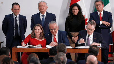 Deputy Prime Minister of Canada Chrystia Freeland, left, Mexico's top trade negotiator Jesus Seade, center, and U.S. Trade Representative Robert Lighthizer sign an update to the North American Free Trade Agreement at the national palace in Mexico City, Dec. 10. 2019.
