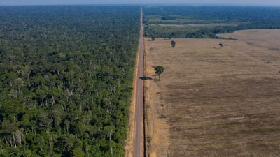 In this Nov. 25, 2019, photo, highway BR-163 stretches between the Tapajos National Forest, left, and a soy field in Belterra, Para state, Brazil.