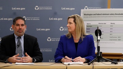 Washington state Labor and Industries Director Joel Sacks, left, and Deputy Director Elizabeth Smith talk about new overtime rules during a news conference, Dec. 11, 2019, in Tukwila, Wash.