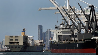 In this May 17, 2019, file photo, a tugboat assists as a container ship is prepared for docking at the Port of Oakland in Oakland, Calif.