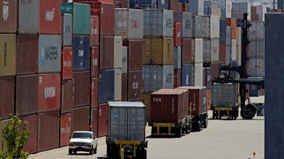 In this July 22, 2019, file, stacked containers wait to be loaded on to trucks at the Port of Oakland in Oakland, Calif.