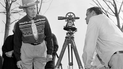 In this April 18, 1958, file photo, Philip N. Brooks, right, a New York State surveyor, takes a look through his transit on the Tuscarora Indian Reservation near Niagara Falls, N.Y., while Tuscarora Chief Elton Black Cloud Greene watches.