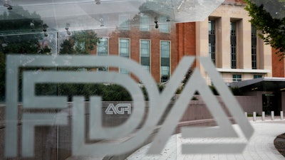 This Aug. 2, 2018, file photo shows the U.S. Food and Drug Administration building behind FDA logos at a bus stop on the agency's campus in Silver Spring, Md.