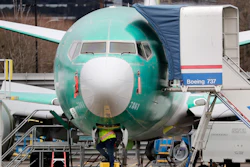 A worker looks up underneath a Boeing 737 Max jet, Dec. 16, 2019, in Renton, Wash.