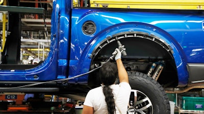 In this Sept. 27, 2018, file photo, an assemblyman works on a 2018 Ford F-150 truck at the Ford Rouge plant in Dearborn, Mich.