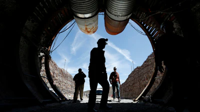 In this April 9, 2015, file photo, people walk into the south portal of Yucca Mountain during a congressional tour of the proposed radioactive waste dump near Mercury, Nev.