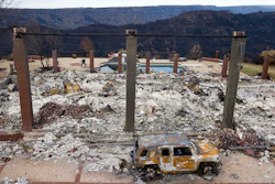 In this Dec. 3, 2018, file photo, a vehicle rests in front of a home leveled by the Camp Fire in Paradise, Calif.