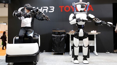 In this Dec. 18, 2019, photo, Toyota's human-shaped T-HR3 robot is remotely controlled by its staff member during a demonstration in Tokyo.