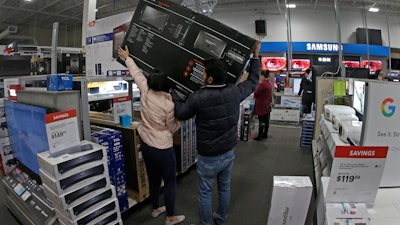 In this Nov. 28, 2019, file photo, people shop at a Best Buy store during a Black Friday sale in Overland Park, Kan.