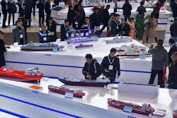 In this Dec. 3, 2019, photo, visitors look at the ship models exhibited by the China State Shipbuilding Corporation during the Marintec China exhibition in Shanghai.