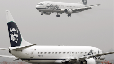 An Alaska Airlines plane comes in for a landing as another taxis for takeoff at Seattle-Tacoma International Airport, Jan. 16, 2009.