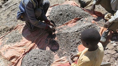François and his 13-year-old son, Charles, sort stones before taking them to a nearby trading house that buys the ore, Democratic Republic of Congo, 2016.