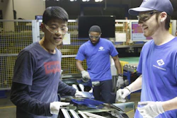 This image released by Netflix shows Wong He, left, working with Kenny Taylor, center, and Jarred Gibson, right, in the furnace tempering area of the Fuyao Glass America Factory in the film 'American Factory.'