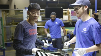 This image released by Netflix shows Wong He, left, working with Kenny Taylor, center, and Jarred Gibson, right, in the furnace tempering area of the Fuyao Glass America Factory in the film 'American Factory.'