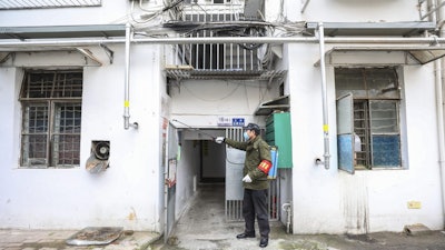 A government worker sprays disinfectant on a residential building in Wuhan, China, Jan. 28, 2020.