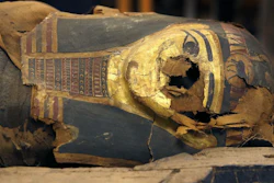 In this Dec. 5, 2014, photo, the mummified body of Minirdis, a 14-year-old Egyptian boy, and his burial mask in an opened coffin at the Field Museum in Chicago.
