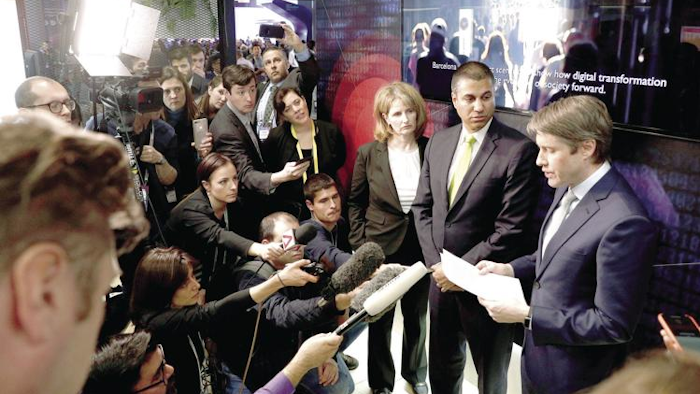 Robert Strayer, right, and FCC Chairman Ajit Pai, center, at a press conference at the Mobile World Congress show in Barcelona, Feb. 26, 2019.