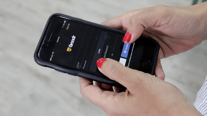In this May 29, 2019, file photo, a woman checks the Grindr app on her mobile phone in Beirut, Lebanon.
