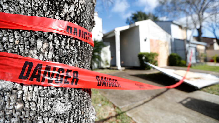 Red 'danger' tape circles a damaged home on Bridgeland Lane in Houston, Jan. 26, 2020.