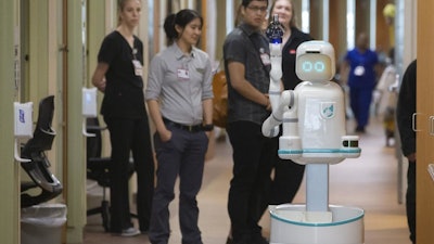 Hospital staff and representatives from Diligent Robotics watch Moxi, a medical assistant robot, at the University of Texas Medical Branch’s Jennie Sealy Hospital, Jan. 2019, Galveston, Texas.