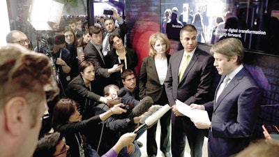 Robert Strayer, right, and FCC Chairman Ajit Pai, center, at a press conference at the Mobile World Congress show in Barcelona, Feb. 26, 2019.