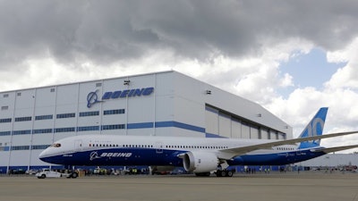 Boeing employees stand near an 787-10 Dreamliner after its first test flight, North Charleston, S.C., March 31, 2017.