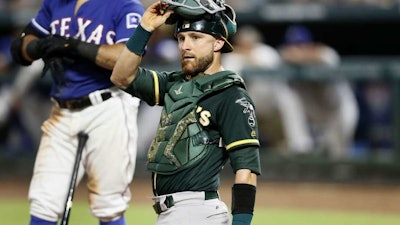 Oakland Athletics catcher Jonathan Lucroy looks to the dugout during a baseball game against the Texas Rangers, July 24, 2018, in Arlington, Texas.