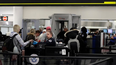 A Transportation Security Administration officer works at the entrance to Concourse G at Miami International Airport, Jan. 11, 2019.