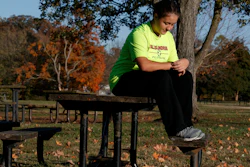 Grace Brown, 14, adjusts her fitness tracker at the park where she does her jogging workouts for her 'online PE' class, Alexandria, Va., Nov. 1, 2019.